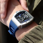 Motorsport-inspired luxury watch with skeleton dial and blue rubber strap on wrist