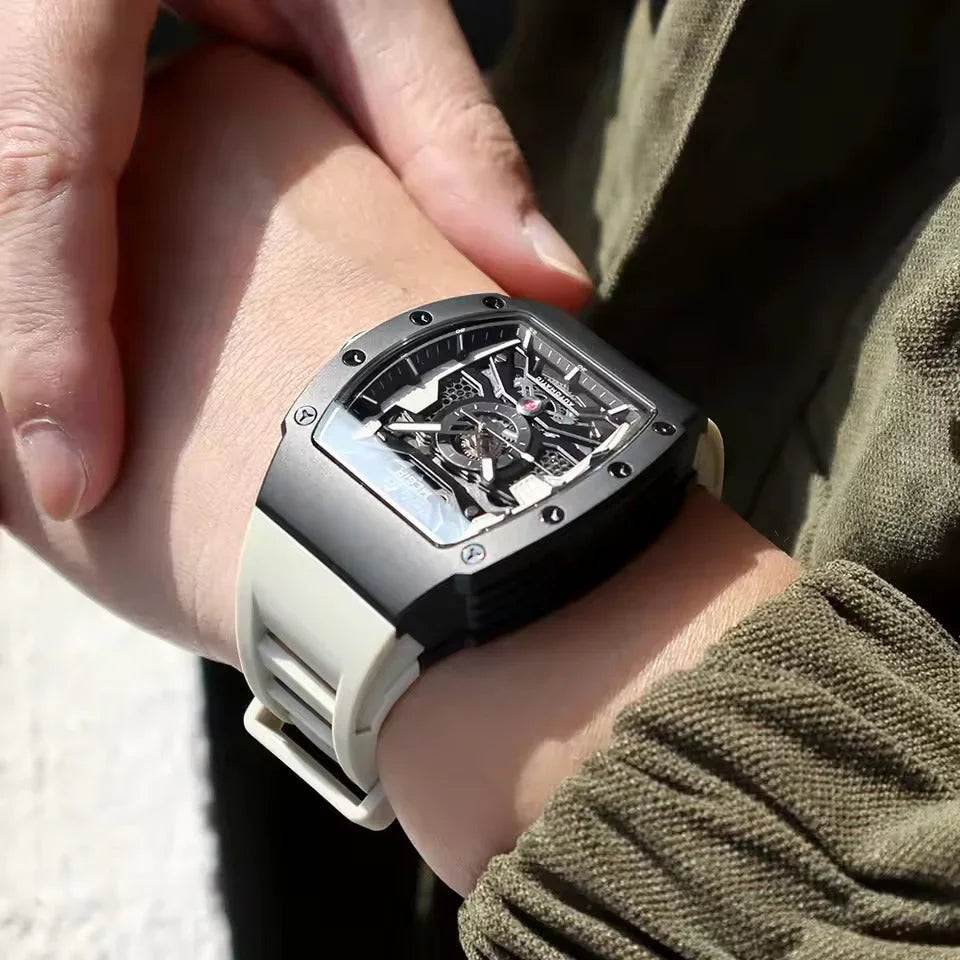Luxury motorsport-inspired skeleton watch with rectangular case and white strap on wrist