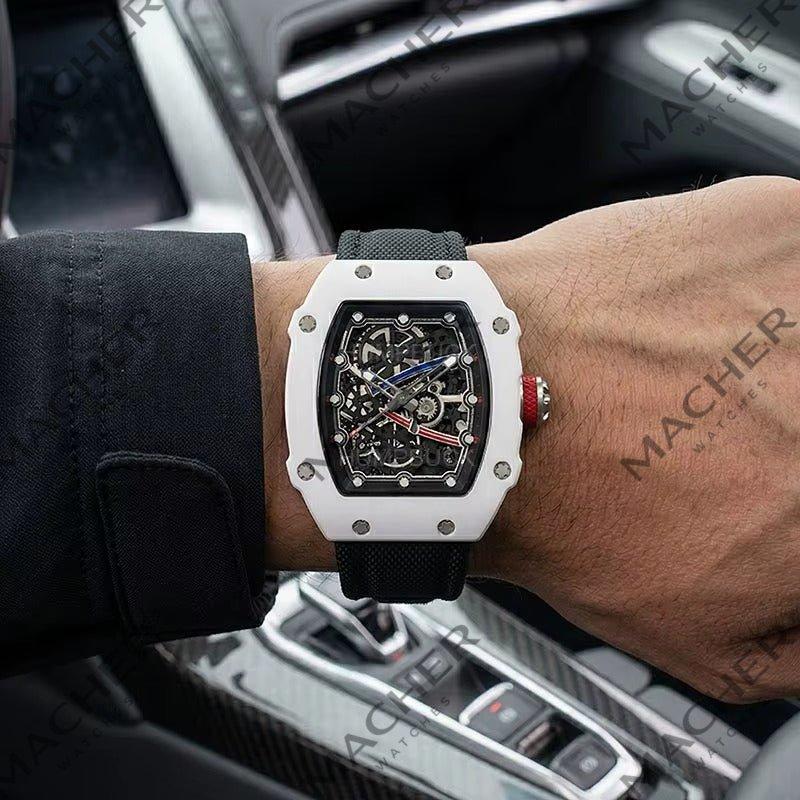 Luxury skeleton watch with white case, black strap, red crown, worn in car — motorsport-inspired design