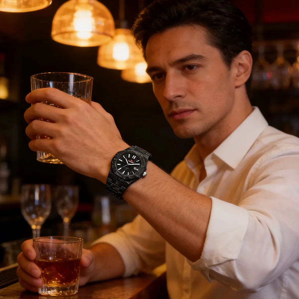 Man in bar wearing black luxury sport watch with bold dial and metal bracelet, motorsport-inspired