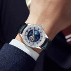 Luxury sport watch with blue galaxy dial, diamond bezel, and black leather strap on wrist