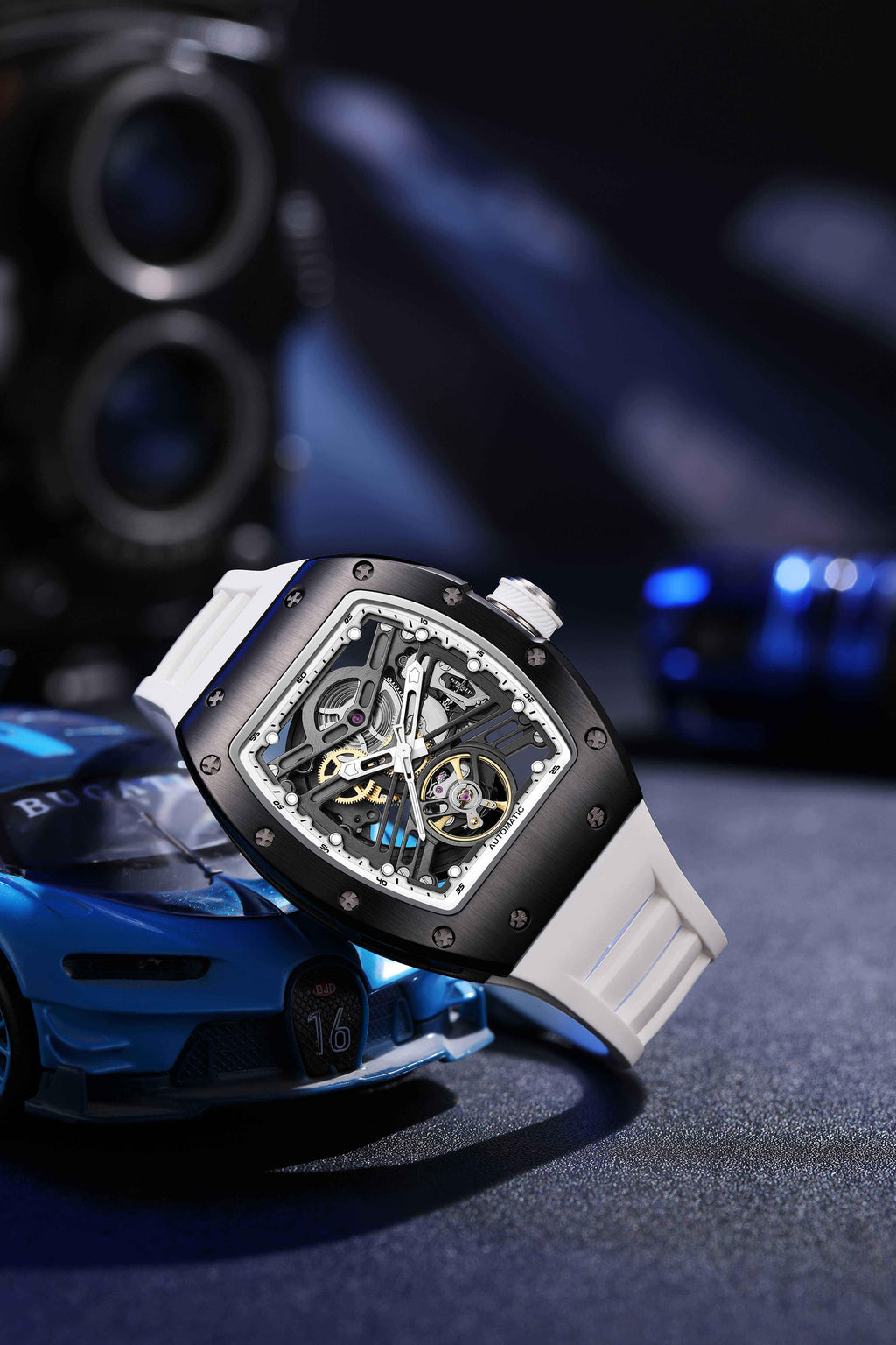 Motorsport-inspired skeleton automatic watch with tonneau case and white strap, sporty car backdrop