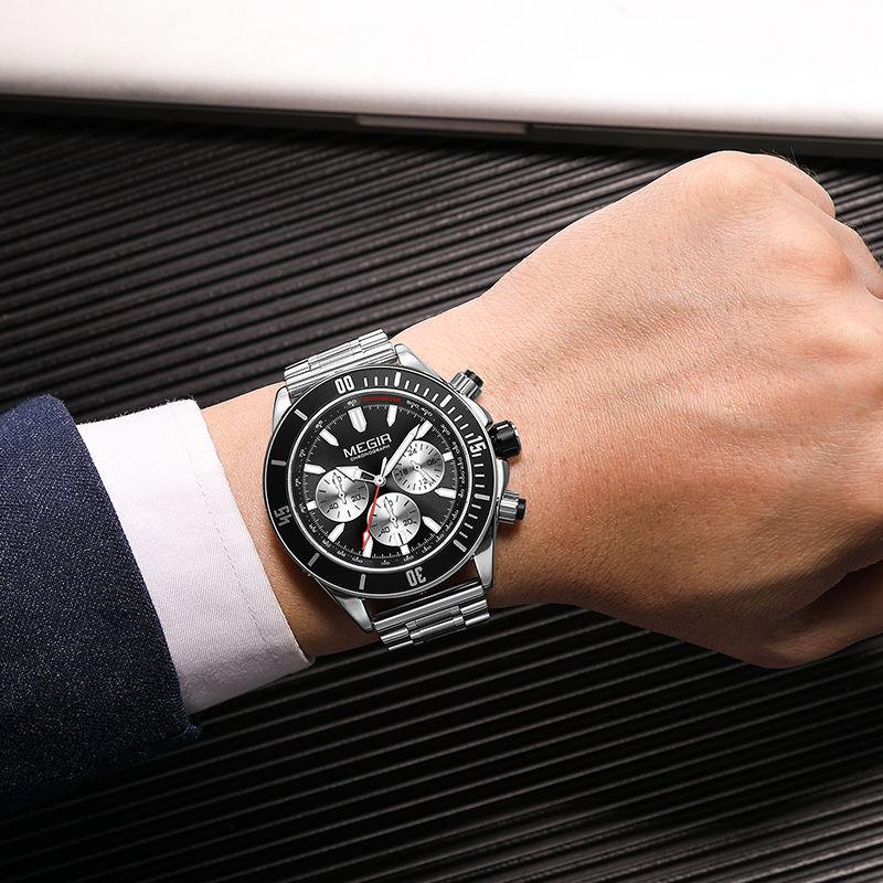 Luxury sport-luxury chronograph watch with black dial, silver subdials, and metal bracelet on wrist