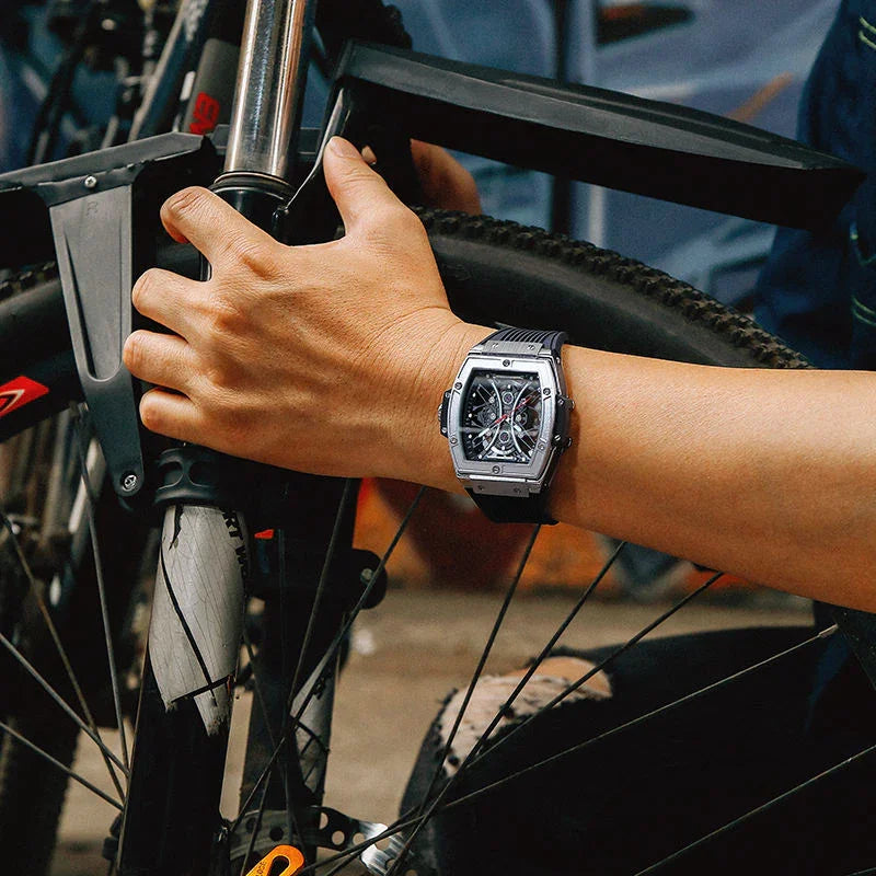 Luxury motorsport-inspired chronograph watch with skeleton dial worn while holding a bicycle