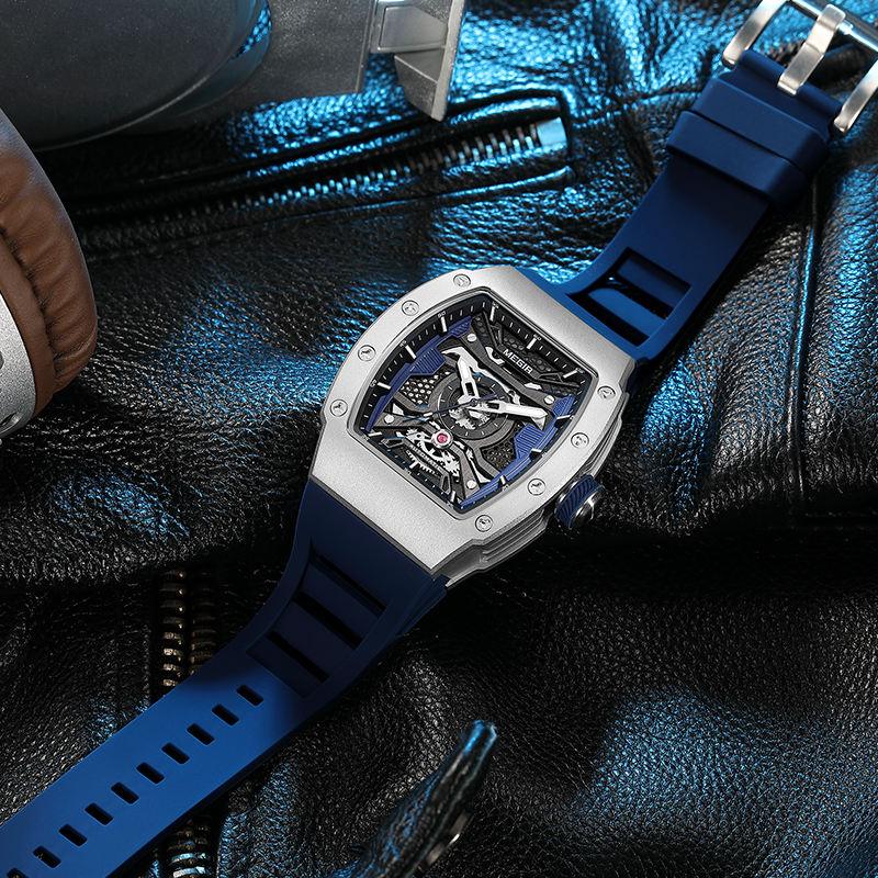 Motorsport-inspired skeleton dial watch with blue rubber strap on black leather background